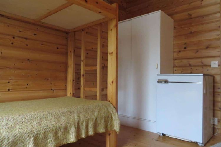 Makuuhuone kerrossängyllä, vaatekaapilla ja jääkaapilla varustettuna.