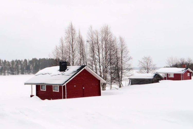 Mökki talvisessa rantamaisemassa.