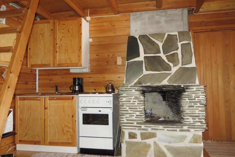 Keittiönurkkaus, jossa uuni/hella ja kivitakka.