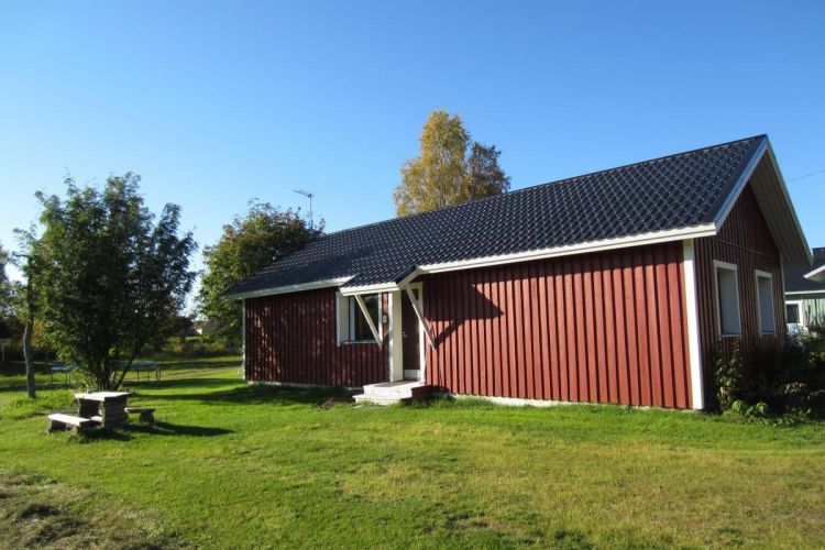 Pihatalo ulkoa kuvattuna, edustalla ulkoruokapöytä.